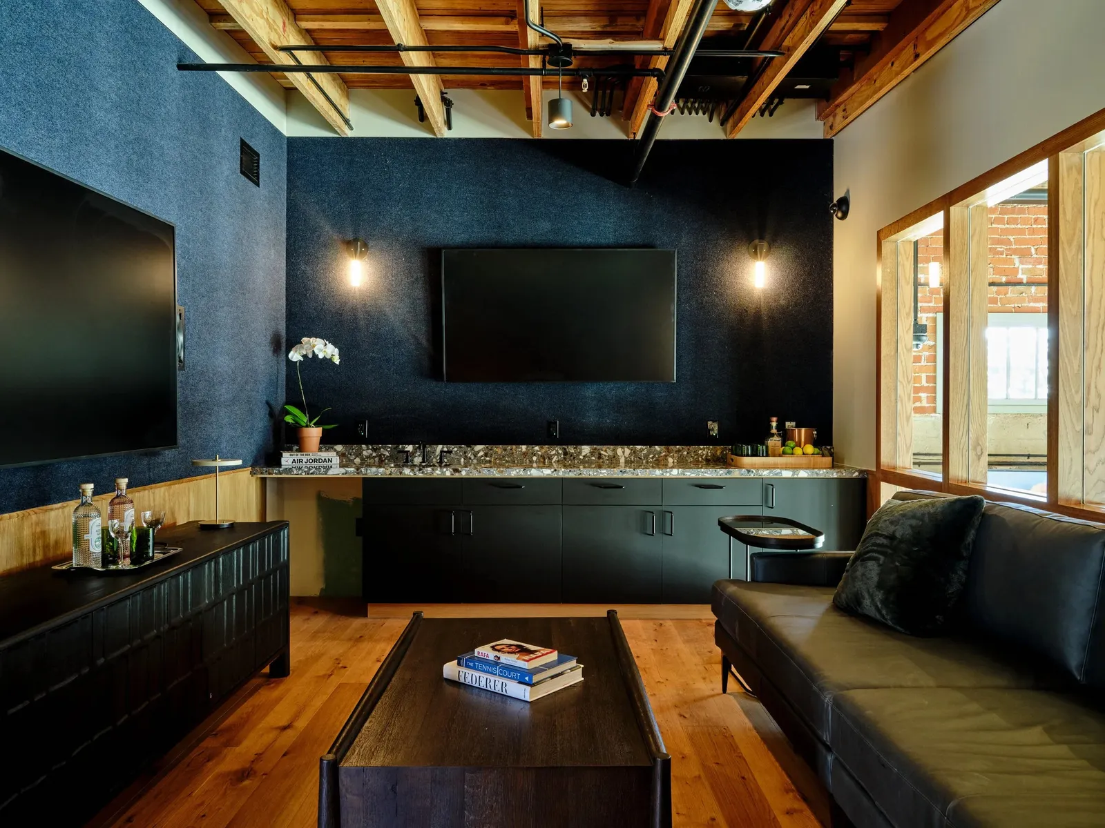 A lounge with a dark bar and leather sofas